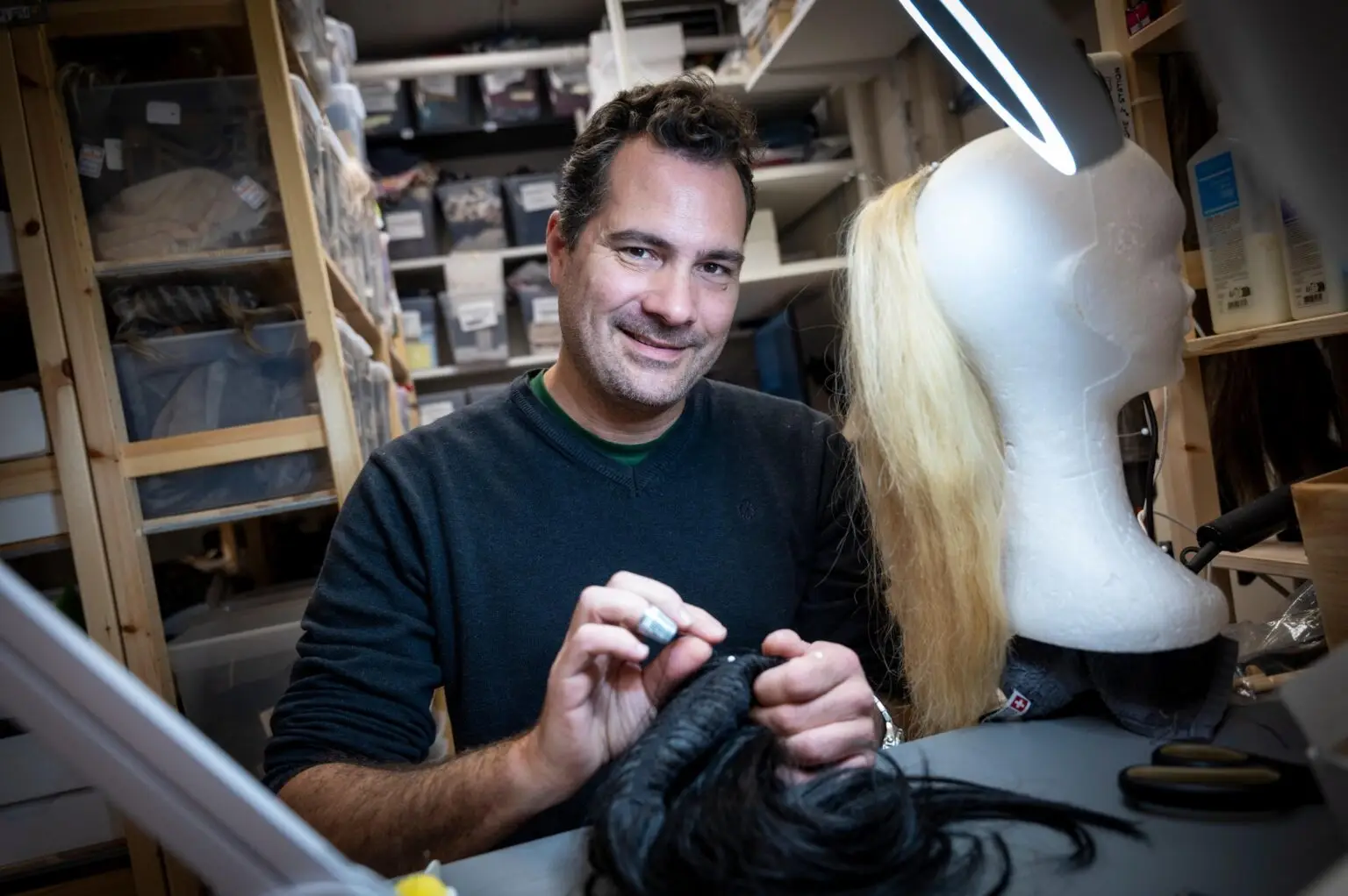 Perruquier de Perruques Michel qui travaille une perruque dans l’atelier